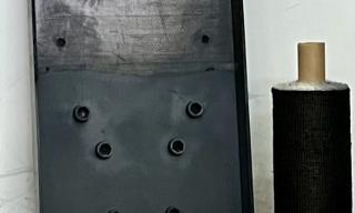 Prototipo 1: tessuto in fibra di carbonio che costituisce un semilavorato per materiali compositi. Tramite lo stampaggio a caldo di questo  tessuto eco-innovativo si può realizzare un dimostratore applicativo (in questo caso, una base per pompa idraulica, Prototipo 2)